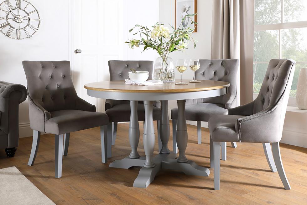 Grey and oak dining table with grey fabric chairs in a well lit contemporary dining room