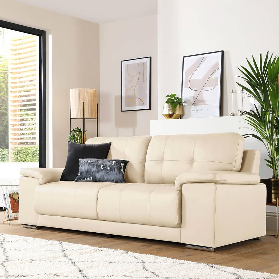 A neutral living room with a cream sofa and white walls