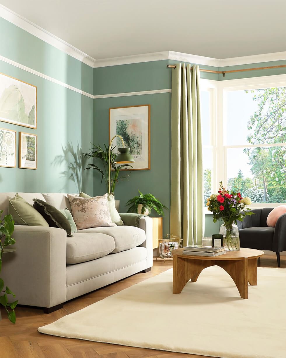 Green living room with window view as the focal point