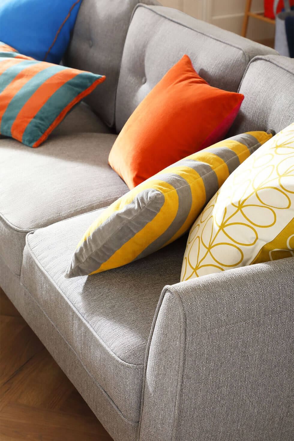 Grey fabric sofa with colourful cushions in bold patterns
