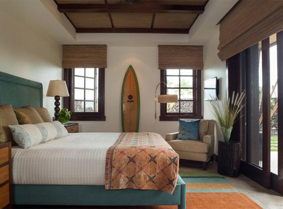 Coastal bedroom with a teal bed, dark wood and beach decor