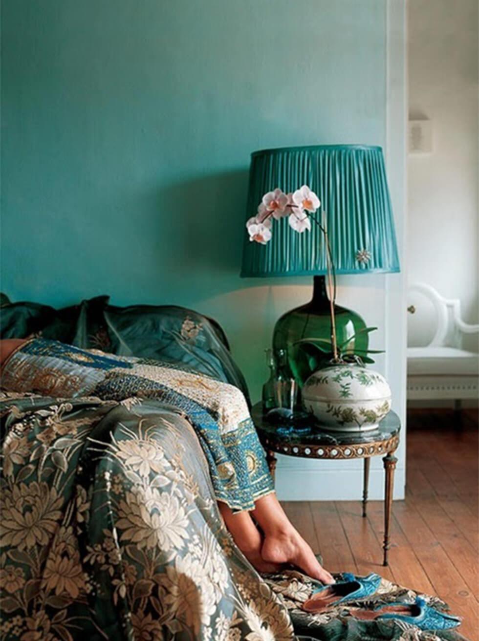 Bohemian bedroom with varying shades of teal on prints, bedding and accessories.