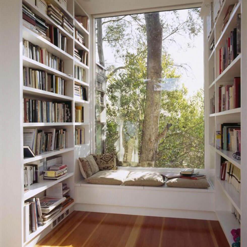 simple white bookcase and reading nook with nature views