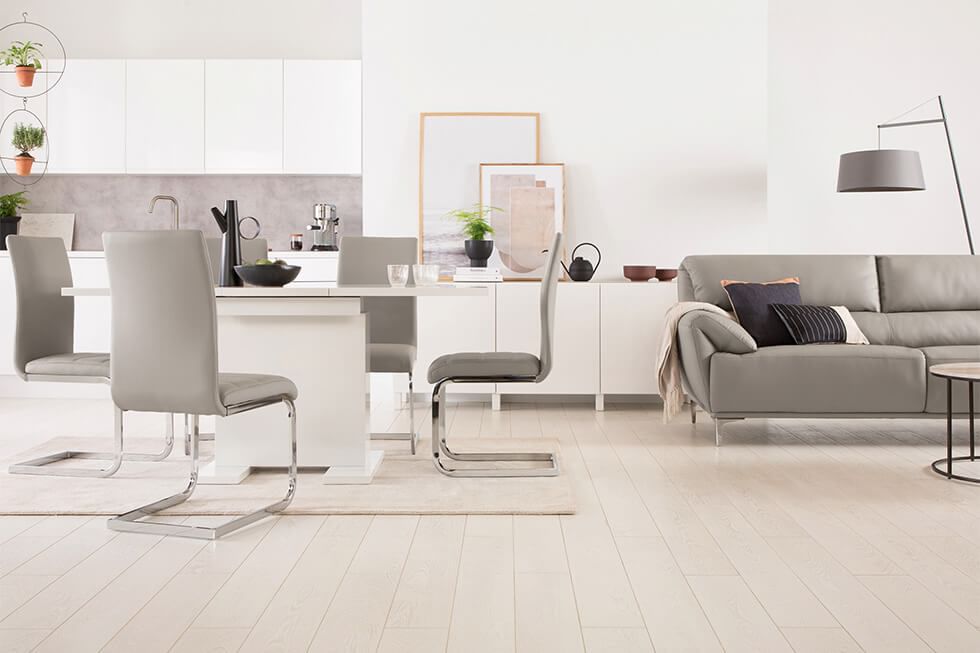 Open plan kitchen lounge in neutral colours with sofa and dining set