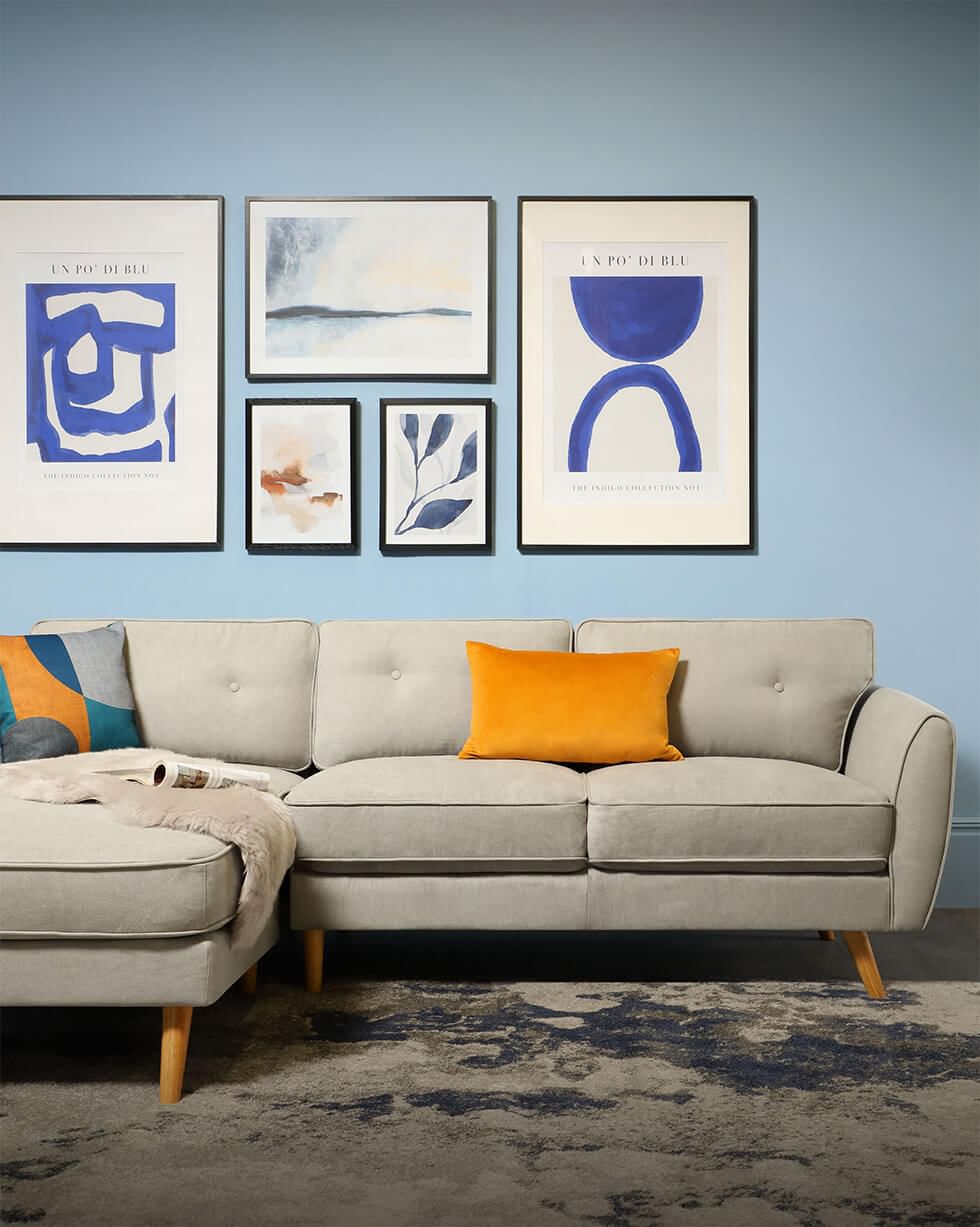 Mid-century modern living room with blue walls and a grey sofa