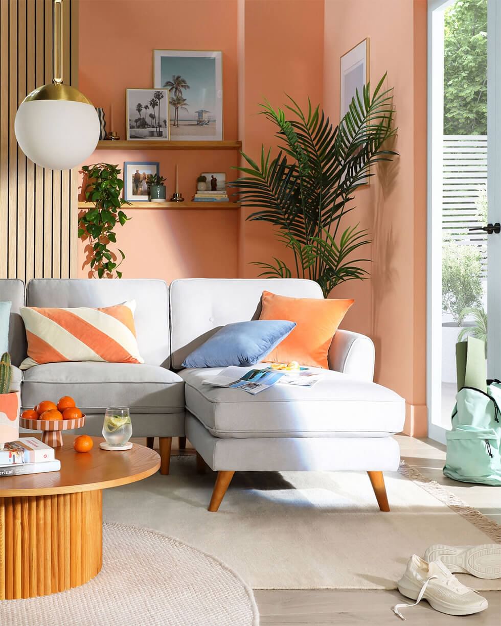 Tropicandi living room with light grey sofa and peach walls