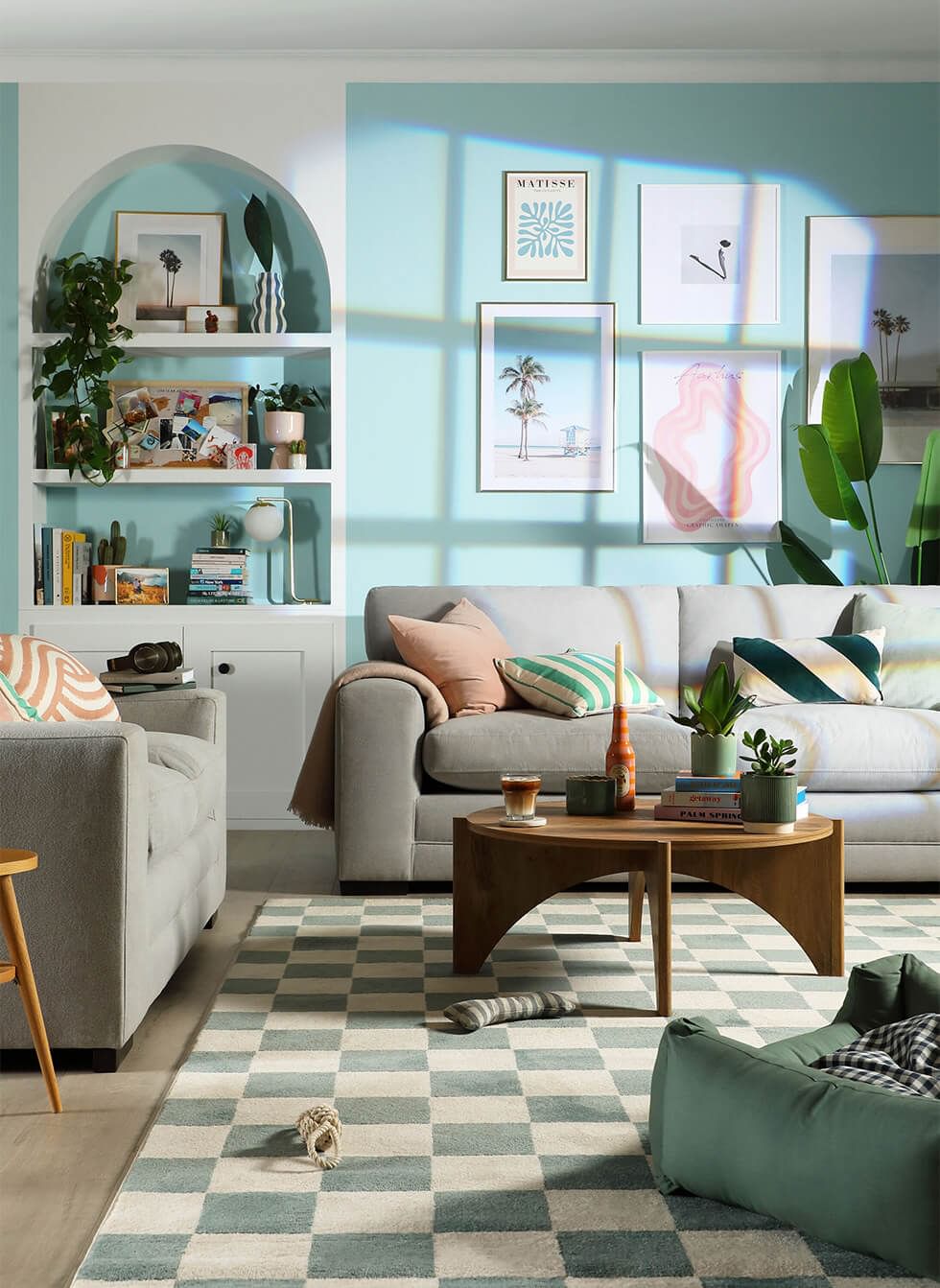 Tropicandi living room with sky blue walls, light grey sofa and lots of natural lighting