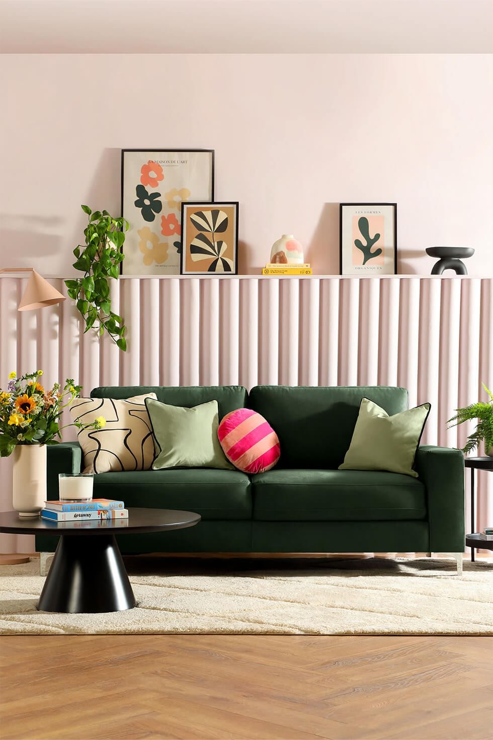 Dopamine decor living room with pink walls and accessories and a green sofa